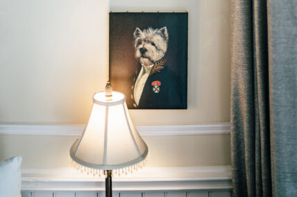 A portrait of a dog head on a human body in the Verandah Room at The Charles Hotel in Niagara-on-the-Lake.