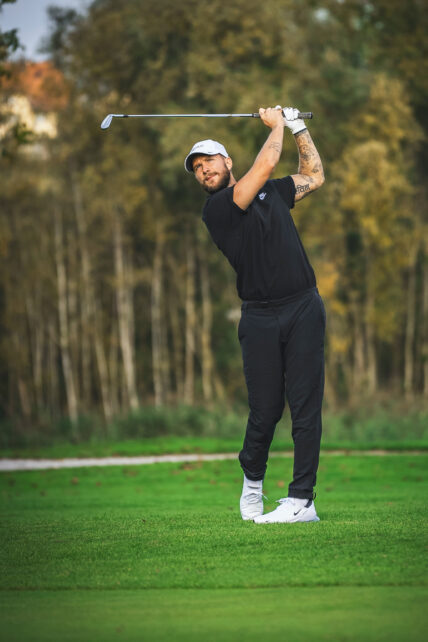 A man swinging a golf club near Niagara's Finest Hotels in Niagara-on-the-Lake.