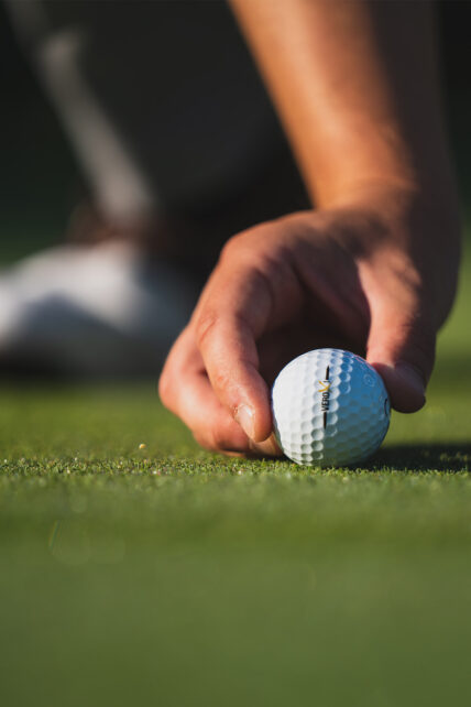 A golf ball being picked up at a green near Niagara's Finest Hotels in Niagara-on-the-Lake.