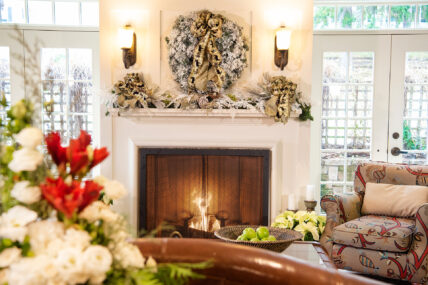 A fireplace with a decorative wreath above it as part of the Holidays at Harbour House package.