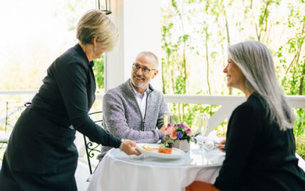 A man being served at a an outdoor dining area as part of the Niagara's finest escape package.