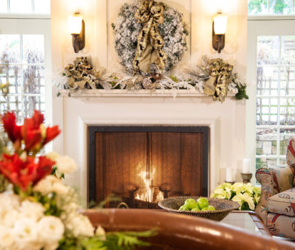 A fireplace with a decorative wreath above it as part of the Holidays at Harbour House package.