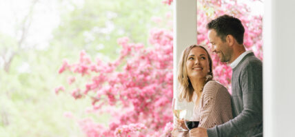 A couple drinking wine together on a balcony as part of the Niagara's finest escape package.