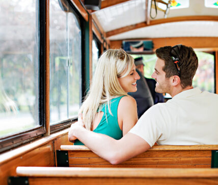 Two people sitting on a wine trolley, an experience offered at Niagara's Finest Hotels in Niagara-on-the-Lake.