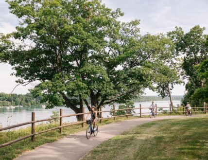 People riding bikes along a trail near Niagara's Finest Hotels in Niagara-on-the-Lake.