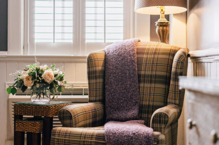 A chair with a blanket on it in the Library Room at The Charles Hotel in Niagara-on-the-Lake.