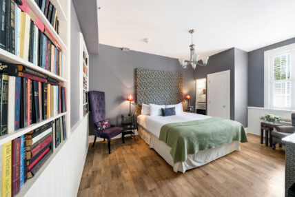 A wide shot of the bedroom in the Library Room at The Charles Hotel in Niagara-on-the-Lake.