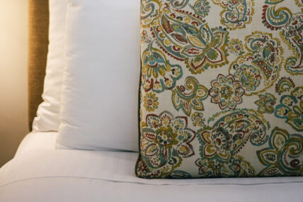 A close up of a decorative pillow on the bed in the Apple Room at The Charles Hotel in Niagara-on-the-Lake.