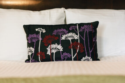 A decorative pillow on a bed in the Poppy Room in The Charles Hotel in Niagara-on-the-Lake.