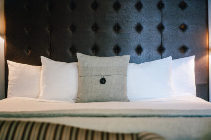 A grey decorative pillow on a bed at The Charles Hotel in Niagara-on-the-Lake.