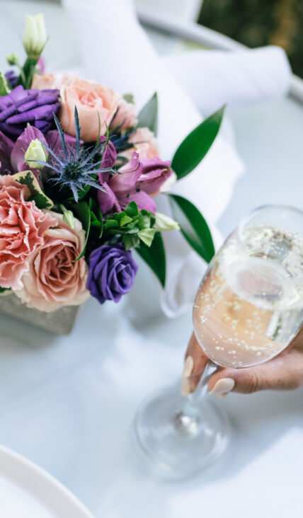 A flower centrepiece on a table and a glass of wine at The Charles Hotel in Niagara-on-the-Lake.