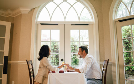 A couple holding hands at a dining table at Harbour House Hotel in Niagara-on-the-Lake.