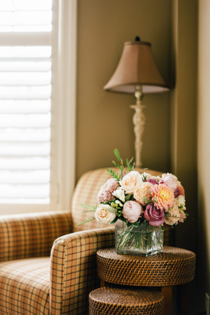 Flowers in a vase beside a chair at Harbour House Hotel in Niagara-on-the-Lake.