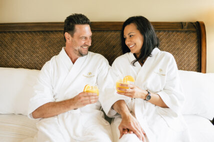 A couple in hotel robes on a bed at Harbour House Hotel in Niagara-on-the-Lake