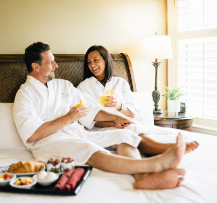 A couple in hotel robes on a bed at Harbour House Hotel in Niagara-on-the-Lake