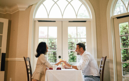 A couple holding hands at a dining table at one of Niagara's Finest Hotels.