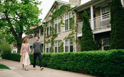 A couple holding hands walking down the street near Niagara's Finest Hotels.