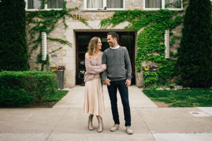 A couple holding eachother, standing outside of the Shaw Club Hotel.