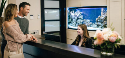 A woman behind a hotel front desk at Niagara's Finest Hotels.