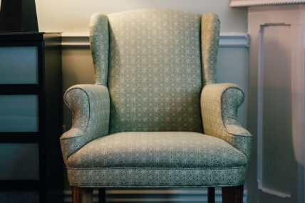 A green chair in the Club Room with Whirlpool and Fireplace at the Shaw Club in Niagara-on-the-Lake.