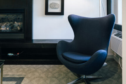 A blue chair in a king suite room at the Shaw Club in Niagara-on-the-Lake.