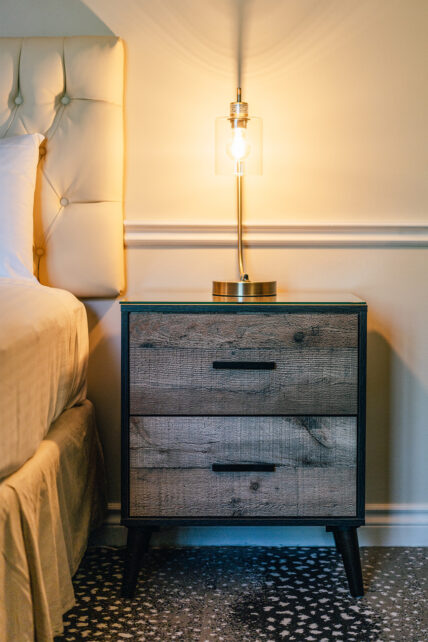 A bedside table with a lamp on it at the Shaw Club in Niagara-on-the-Lake.