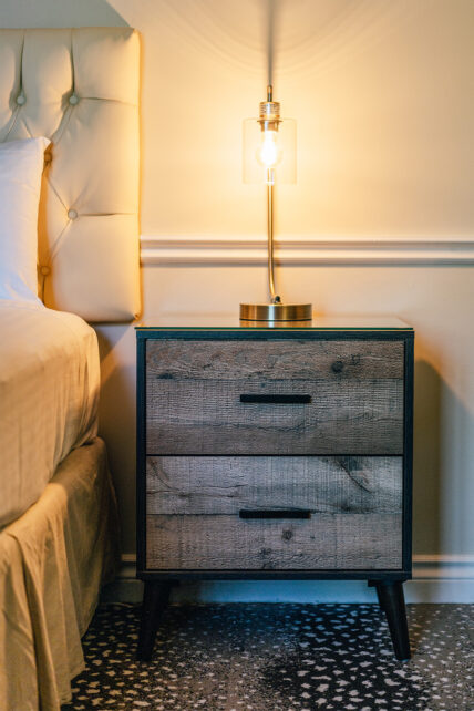 A bedside table with a lamp on it at the Shaw Club in Niagara-on-the-Lake.