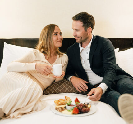 A couple enjoying breakfast in bed at The Shaw Club hotel in Niagara on the Lake