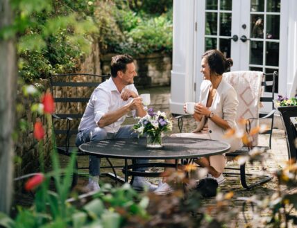 A couple enjoying coffee in the garden at Harbour House Hotel on the Pre Summer Sale