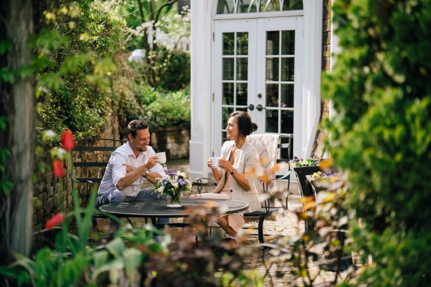 A couple enjoying coffee outside in Harbour House's garden nook.
