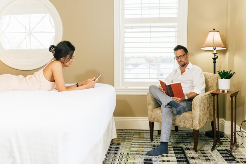 Couple relaxing in their luxurious guestroom at Harbour House Hotel.